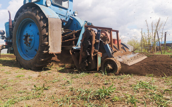 The tractor plows the soil on the field