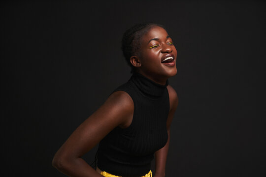 Cheerful African American woman near black background
