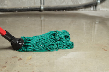 Cleaning up flood in electrical room or basement. Deep water on floor. Close up of mop in water...