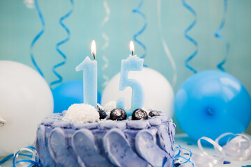 Happy fifteenth birthday card with navy cake and number fifteen candle with blue and white balloons...