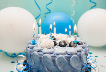 Blue card with birthday cake and candles and white and navy air balloons, celebration and dessert