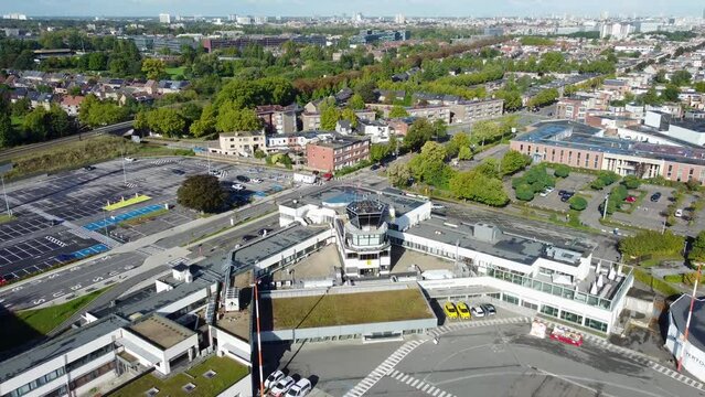 Drone aerial view over Deurne Antwerp airport buildings, ATC Air traffic controller tower and runway and Antwerp city skyline