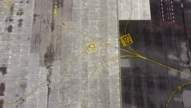 Directional sign markings on the tarmac of runway at commercial airport. Road Marking, Taxiway with yellow signal lines for aircraft