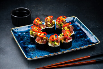 Set of Japanese sushi rolls with raw tuna, cream cheese, avocado, chili peppers and soy sauce.