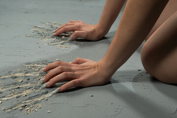Women's hands strongly scratch the painted plaster. Close-up