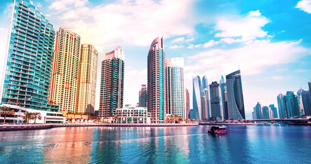 Scenic view of  Dubai Marina in the largest city in the United Arab Emirates against the backdrop of skyscrapers with a boat.