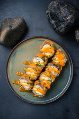 Hot sushi rolls with salmon, eel and Philadelphia cheese and sauce.