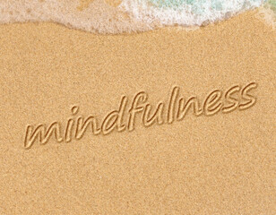 Fototapeta na wymiar mindfulness concept, mindful living, text written on the sand of beach