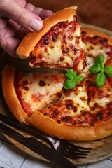 Slice of fresh hot margarita pizza in hand. selective focus