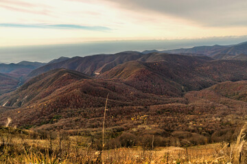 Stunning view of the mountain landscape from a height. View from a height of 1000 m to the peaks of the Caucasus. Stunning view from the top of Mount Peus in the Northwest Caucasus. 