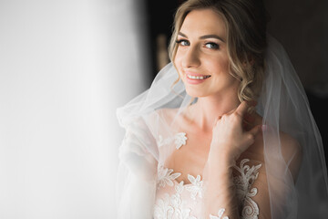 Beauty portrait of bride wearing fashion wedding dress with feathers with luxury delight make-up and hairstyle