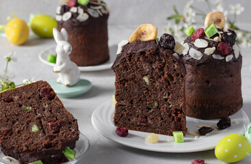 Chocolate Easter Cakes with candied fruits, as well as colorful eggs on gray background. Easter spring still life