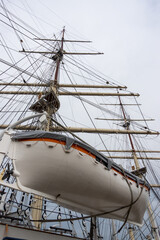 A white lifeboat on the side of a sea sailing ship. Life-saving equipment for seafarers during a...