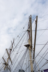 Rigging masts on a deep-sea sailing ship. The mast photographed against a cloudy sky