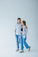 Young happy couple in love in jeans and shirts on a white background. Smiling romantic man and woman.