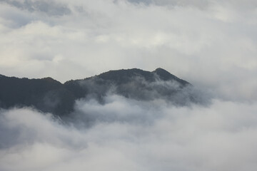 Stunning view of a high hill jutting out of the clouds on the volcanic island of Madeira in the Atlantic Ocean.