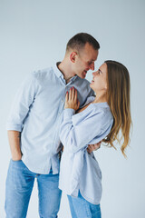 Relationship concept - photo of a happy couple in white shirts and jeans on a white background. Happy young couple