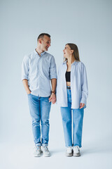 Relationship concept - photo of a happy couple in white shirts and jeans on a white background. Happy young couple