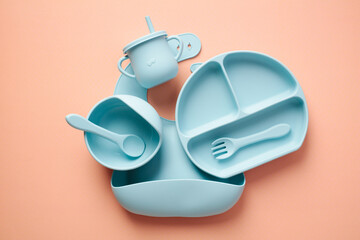 Baby silicone tableware set on color background. Children's feeding concept.