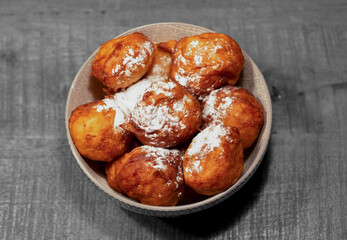 A black and white picture of bowl with oliebollen for new years eve - bowl with deep fried doughnut balls, a dutch tradition