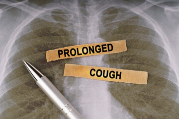 On a human chest x-ray, a pen and strips of paper labeled - Prolonged cough