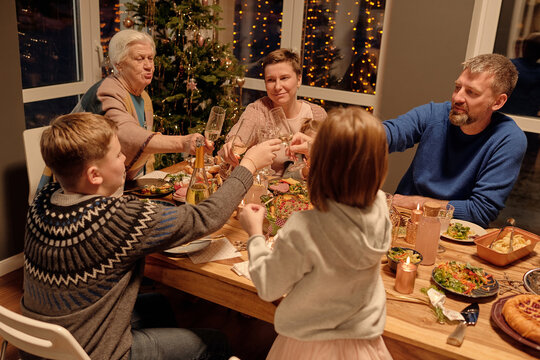 Horizontal picture of family clinking glasses when celebrating Christmas at home
