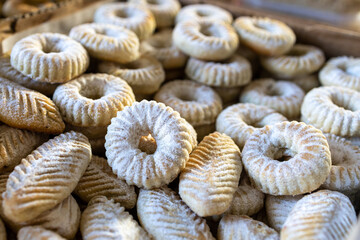 Traditional Arabic biscuits sprinkled with powdered sugar in the shape of a circle in a large box for sale