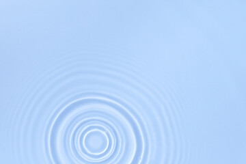 Blue water background with the surface of the blobs of water from the drop, top view
