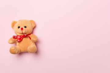 Cute teddy bear on color background, top view