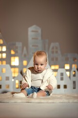 a child against the background of a luminous Christmas decoration moon and houses