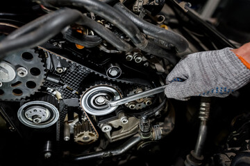 Fototapeta na wymiar Man repairs a car engine. Close-up of a hand with a tool