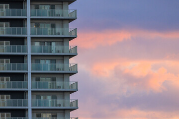 Exterior balconies on luxury apartment tower with beautiful sunset sky