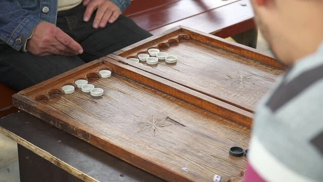  men playing backgammon sitting at the table. High quality FullHD footage