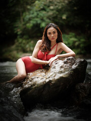 Portraiture shot of a beautiful Asian female model in bikini at a river