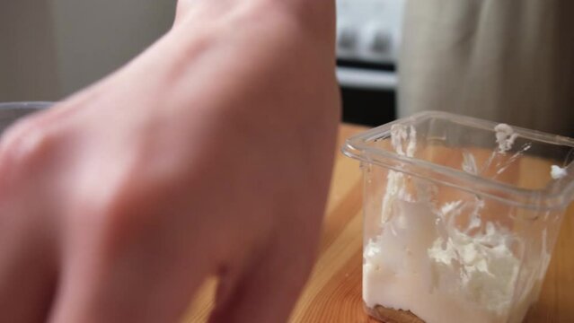 the process of cooking tiramisu. the cook lays out and smears mascarpone on the rows of savoiardi, ladyfinger (biscuit), sponge fingers, boudoirs, baby fingers. mascarpone in tiramisu