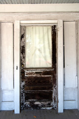 old shabby wooden door with a window on the facade of a house in the old town. Copper elements and painted doorway.