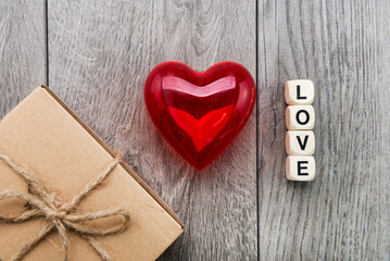Red heart, inscription from wooden cubes LOVE and a gift in a box. concept for Valentine's day.