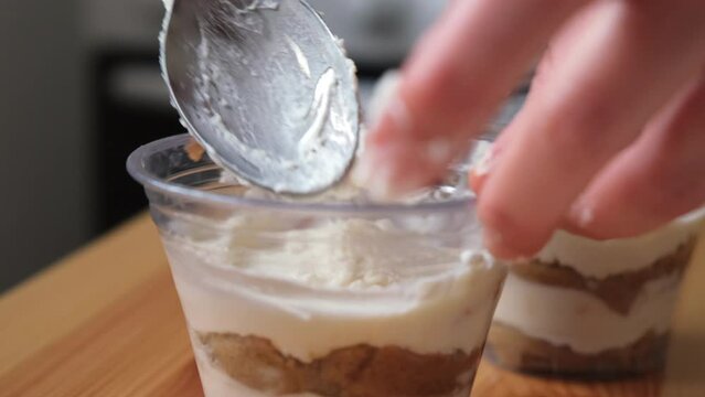 the process of cooking tiramisu. the cook lays out and smears mascarpone on the rows of savoiardi, ladyfinger (biscuit), sponge fingers, boudoirs, baby fingers. mascarpone in tiramisu