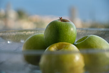 Green apples on a glass bowl