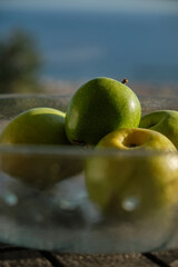 Green apples on a glass bowl