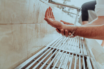 A Muslim performing ablution. Ritual religious cleansing of Muslims before performing prayer. The...