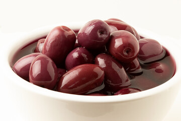 Purple olives in white bowl.