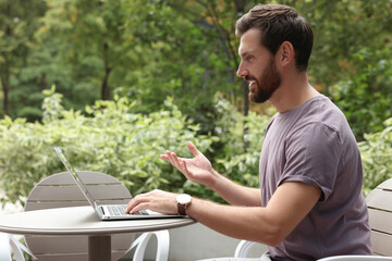 Obraz premium Handsome man with laptop in outdoor cafe