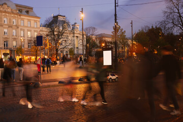 People crossing city street at evening, long exposure effect