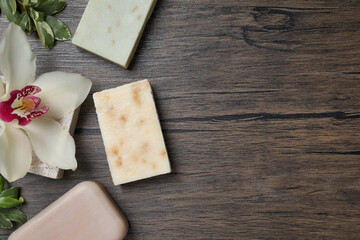 Flat lay composition with different soap bars on wooden table. Space for text