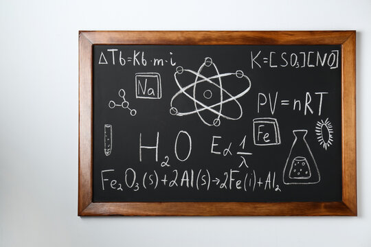 Blackboard with different chemical formulas written with chalk on white wall