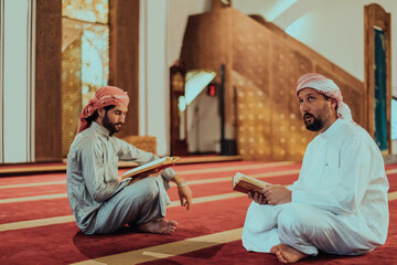 A group of Muslims reading the holy book of the Quran in a modern mosque during the Muslim holiday...