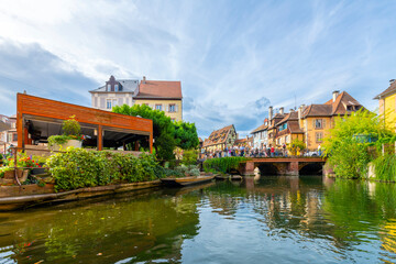 Fototapeta na wymiar View of the Rue Turenne bridge and half timber buildings from a boat on the Lauch canal in the historic medieval Petite Venice district of Colmar, France, in the Alsace region. 