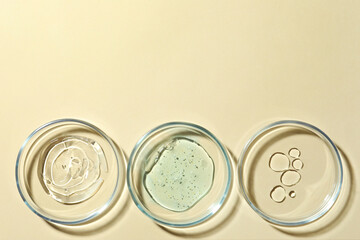 Many Petri dishes and cosmetic products on beige background, flat lay. Space for text