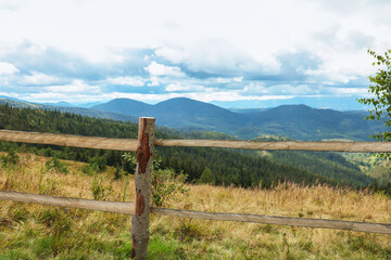 Obraz premium Wooden fence and picturesque view of mountain landscape